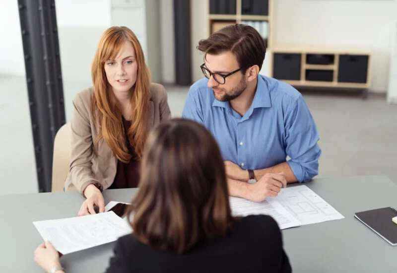 Couple at a table with solicitor discussing documents