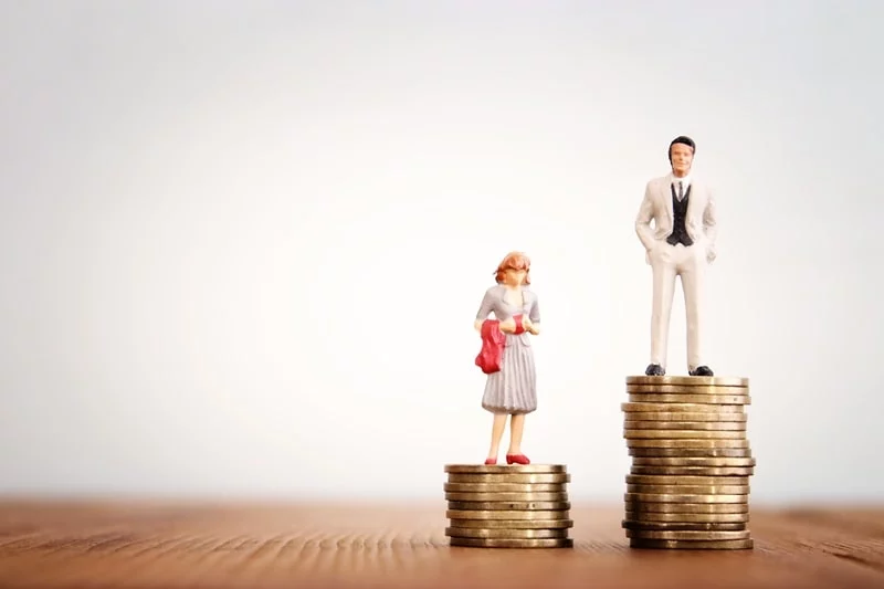 Man and women figure standing on coins to represent gender pay gap