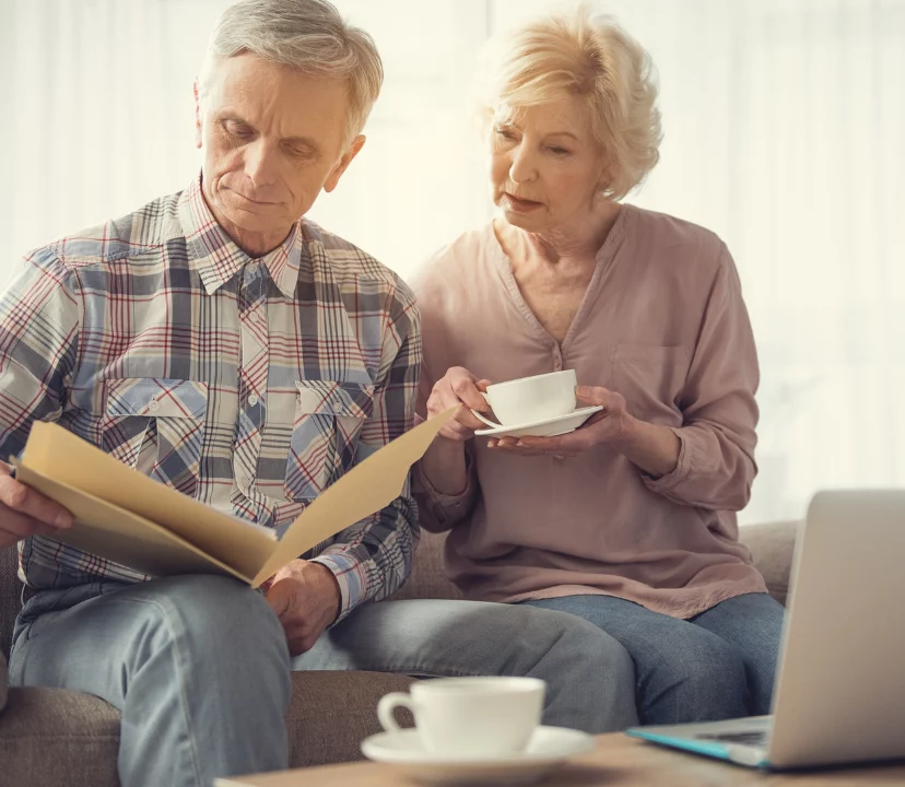 Married couple, man and women looking over documents on a sofa