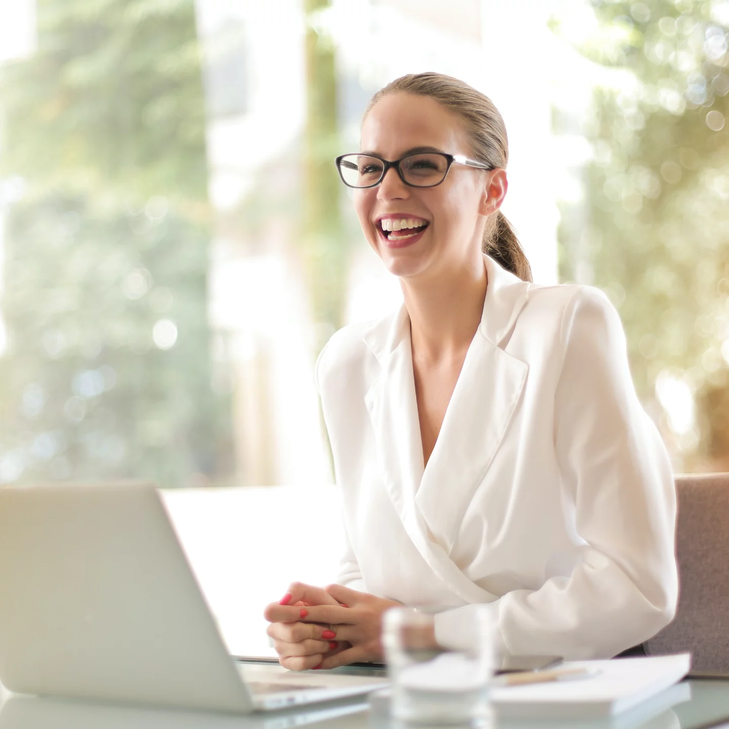 Women laughing at her desk Infront of her laptop