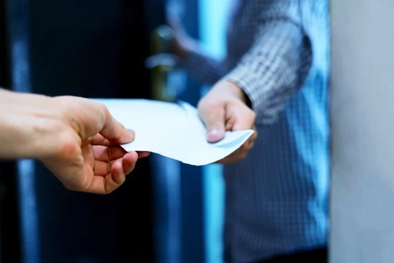envelope being passed between two people