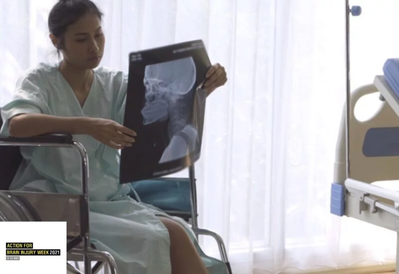 lady in wheelchair in hospital holding x ray results