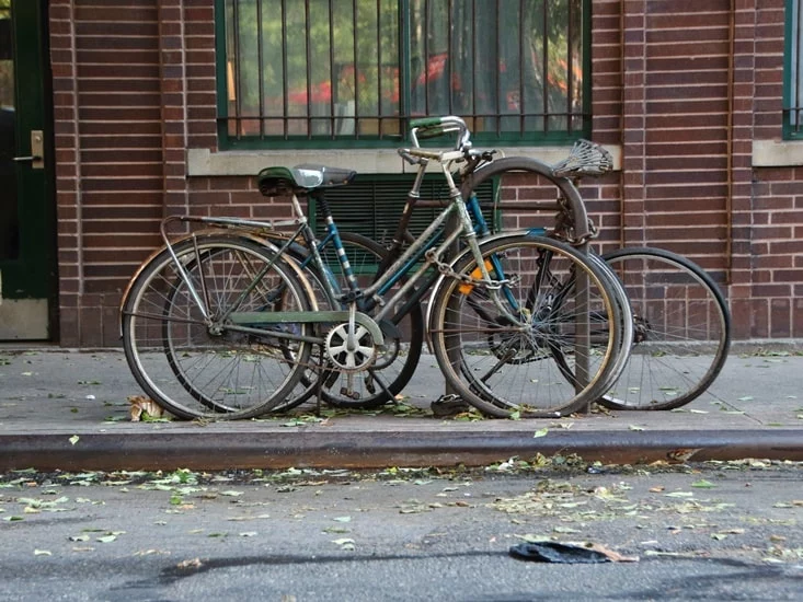 Bikes on the side of a road Infront of a building