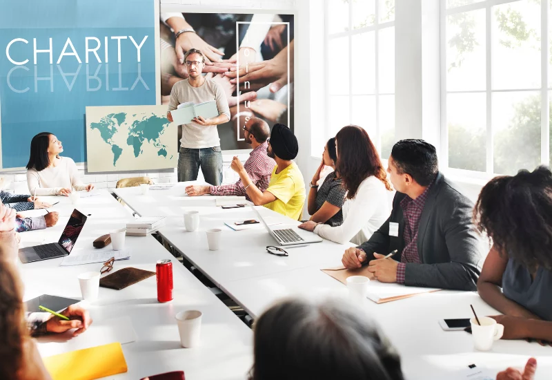 Charity meeting of big long table with man presenting
