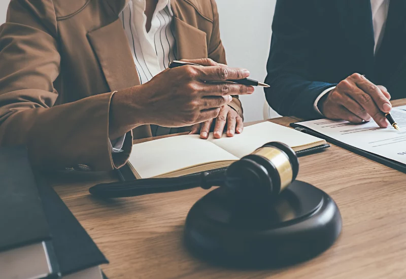 man and women sat with pen and contract with gavel