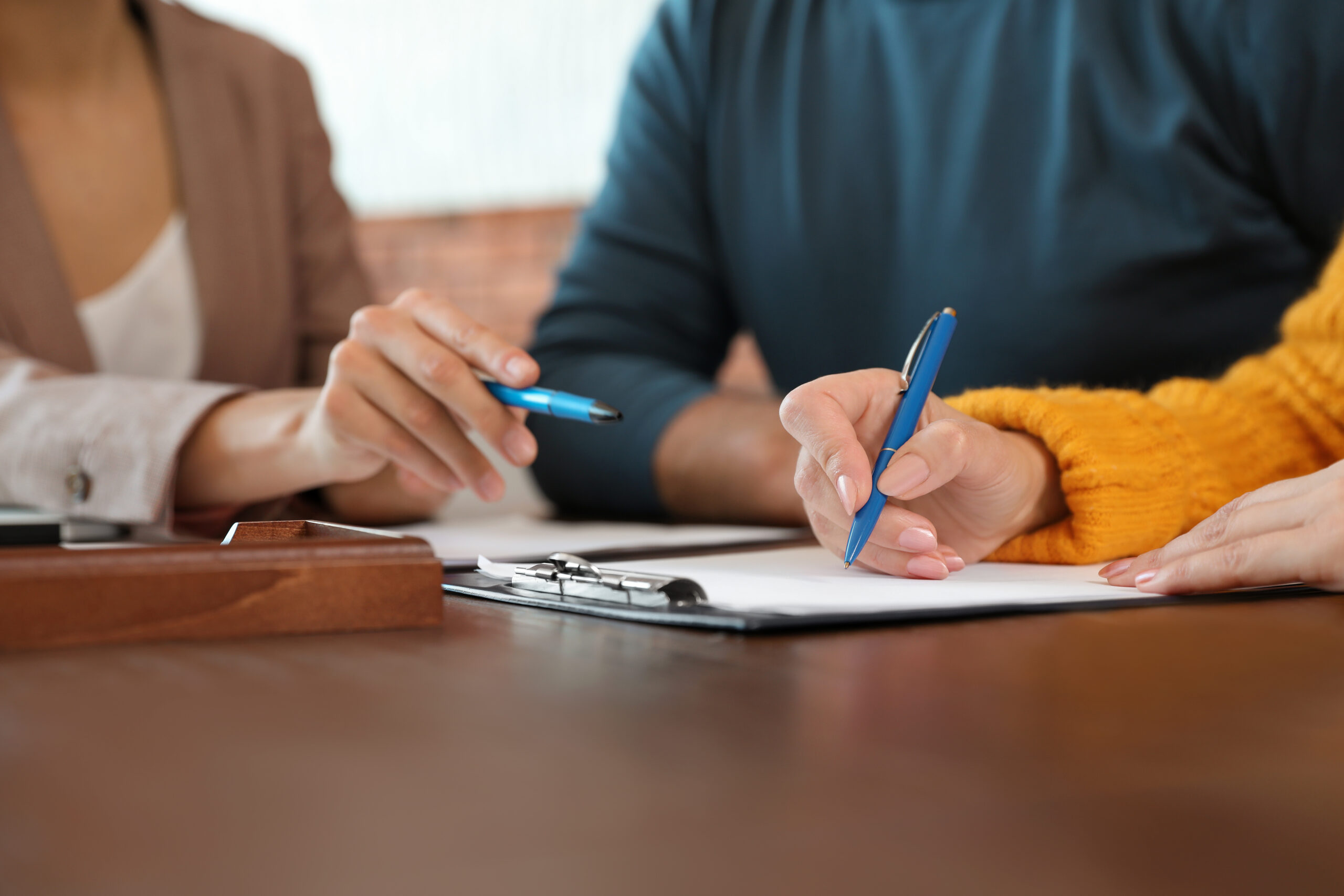 man and women discussing with another person writing it down
