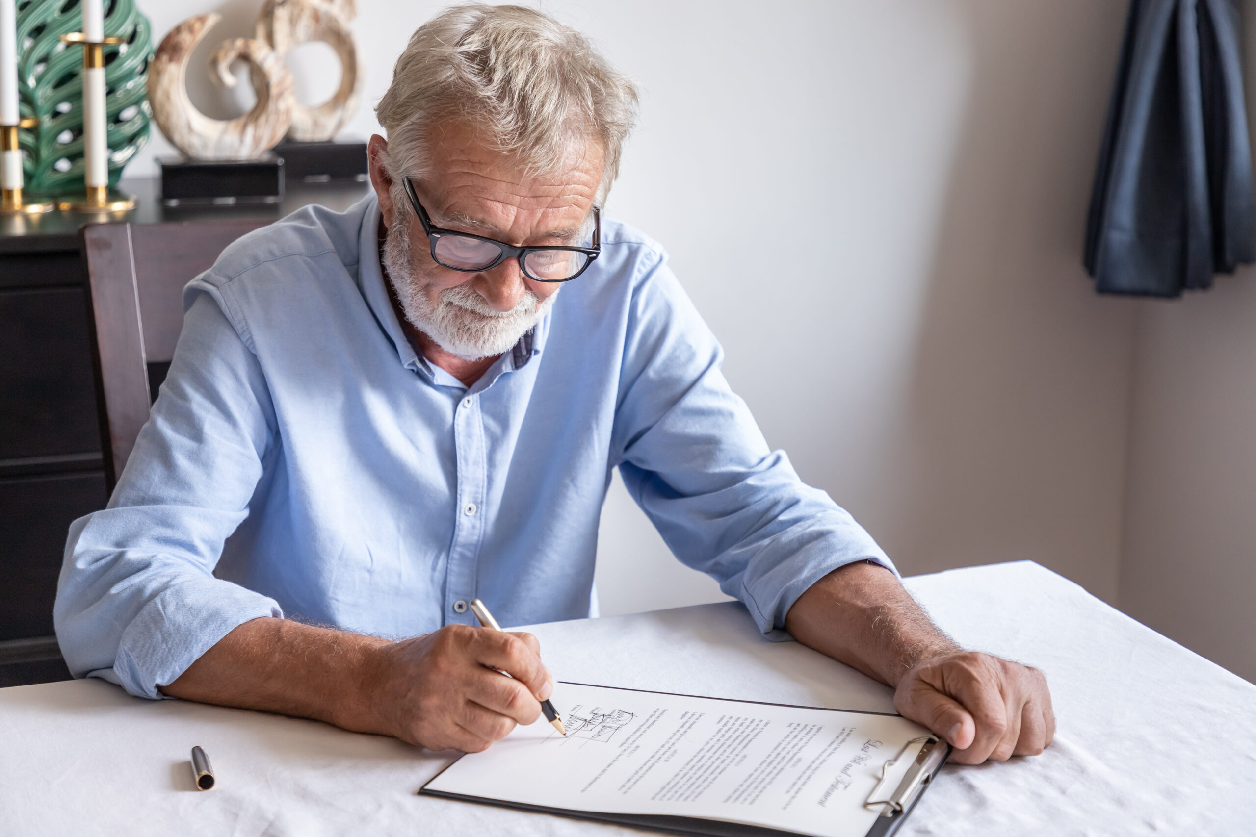 Older man sat signing his will