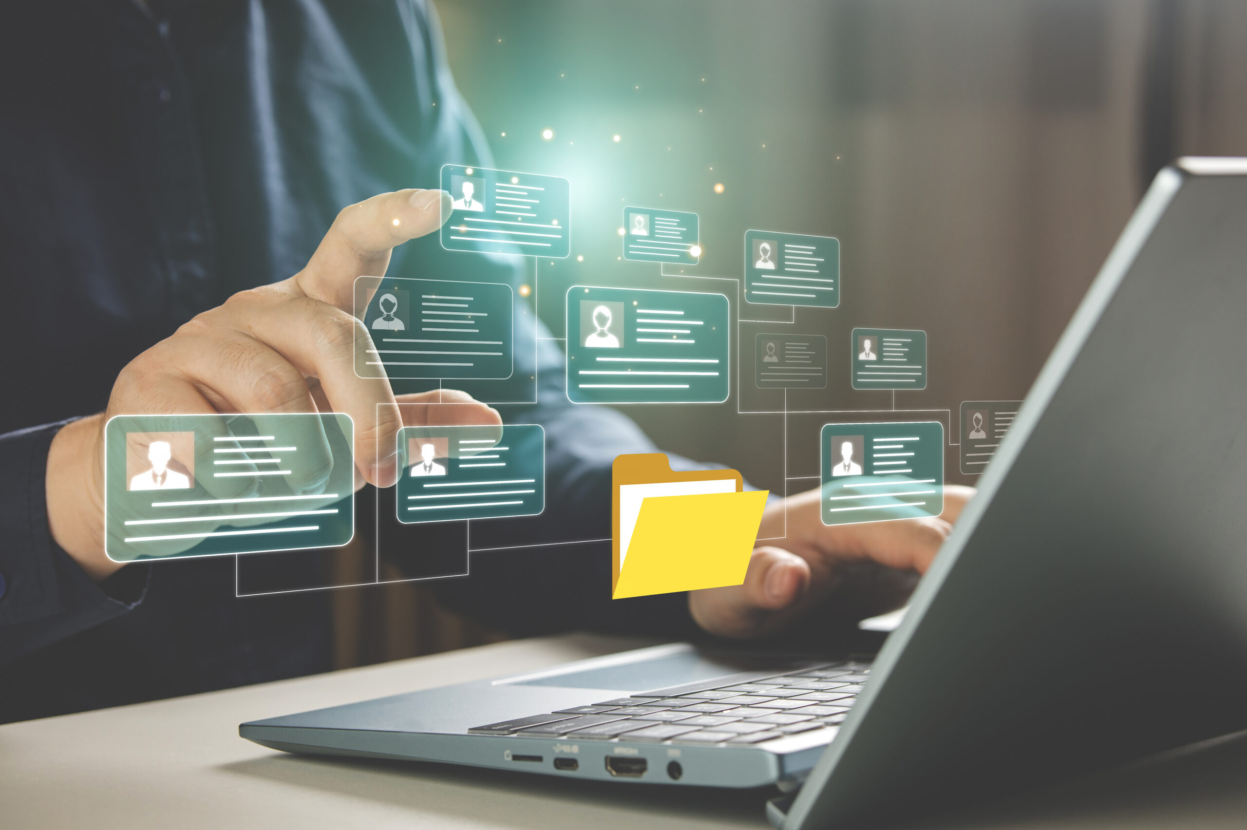 man typing on laptop with personal data as icons which he is tapping