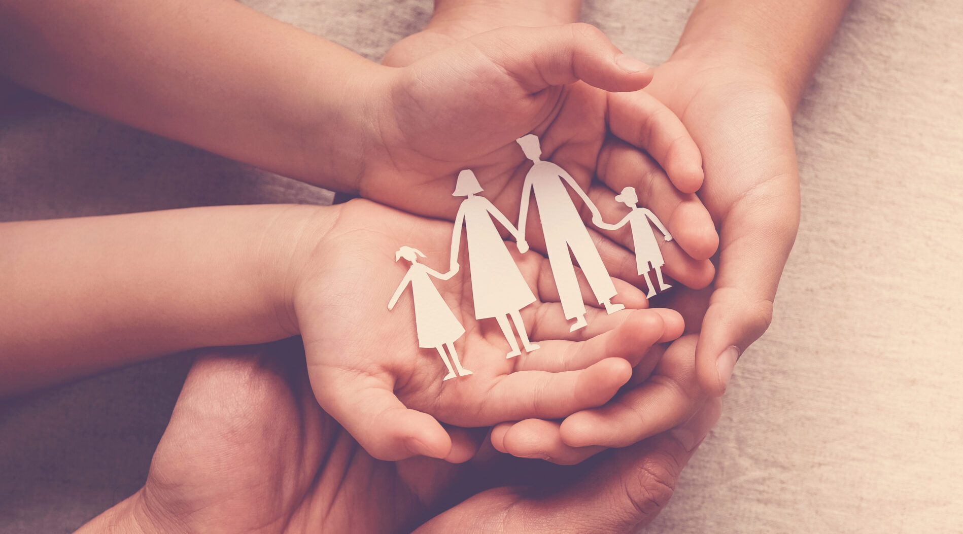 Adult and children hands holding paper family cutout