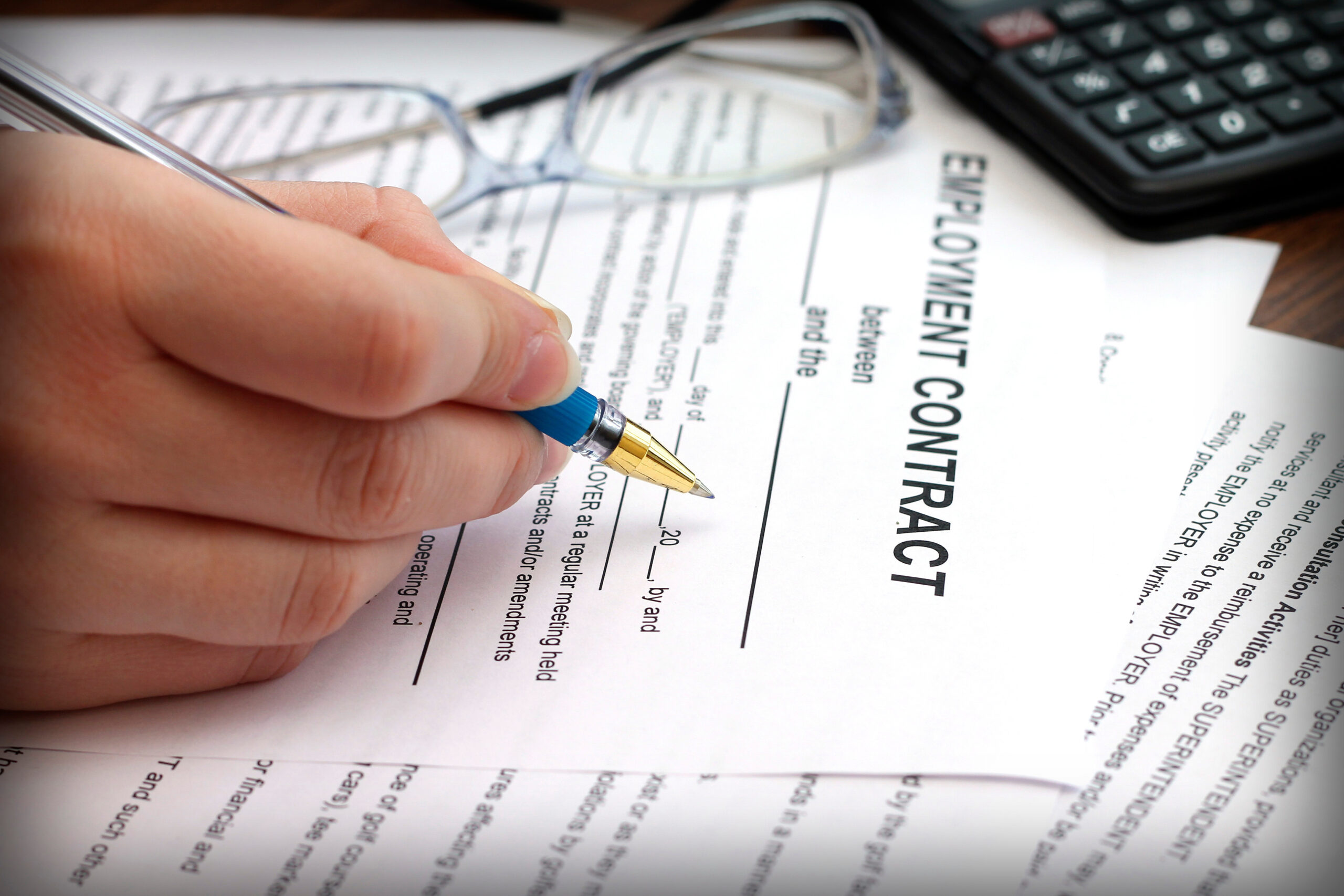 woman's hands signing an employment contract, close-up