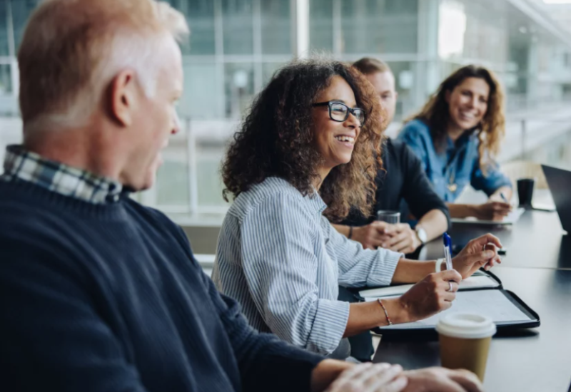 four people in a meeting laughining