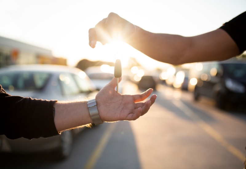 Two hands passing car keys